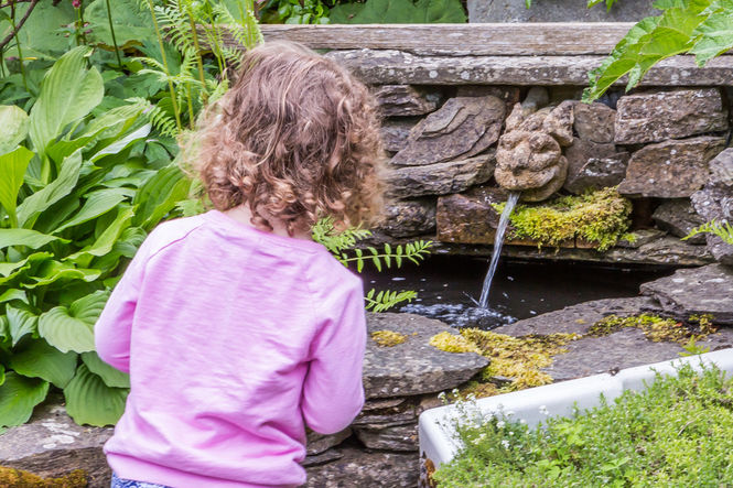 A little girl is mesmerised by water at Duncan Street gardens, Caithness
